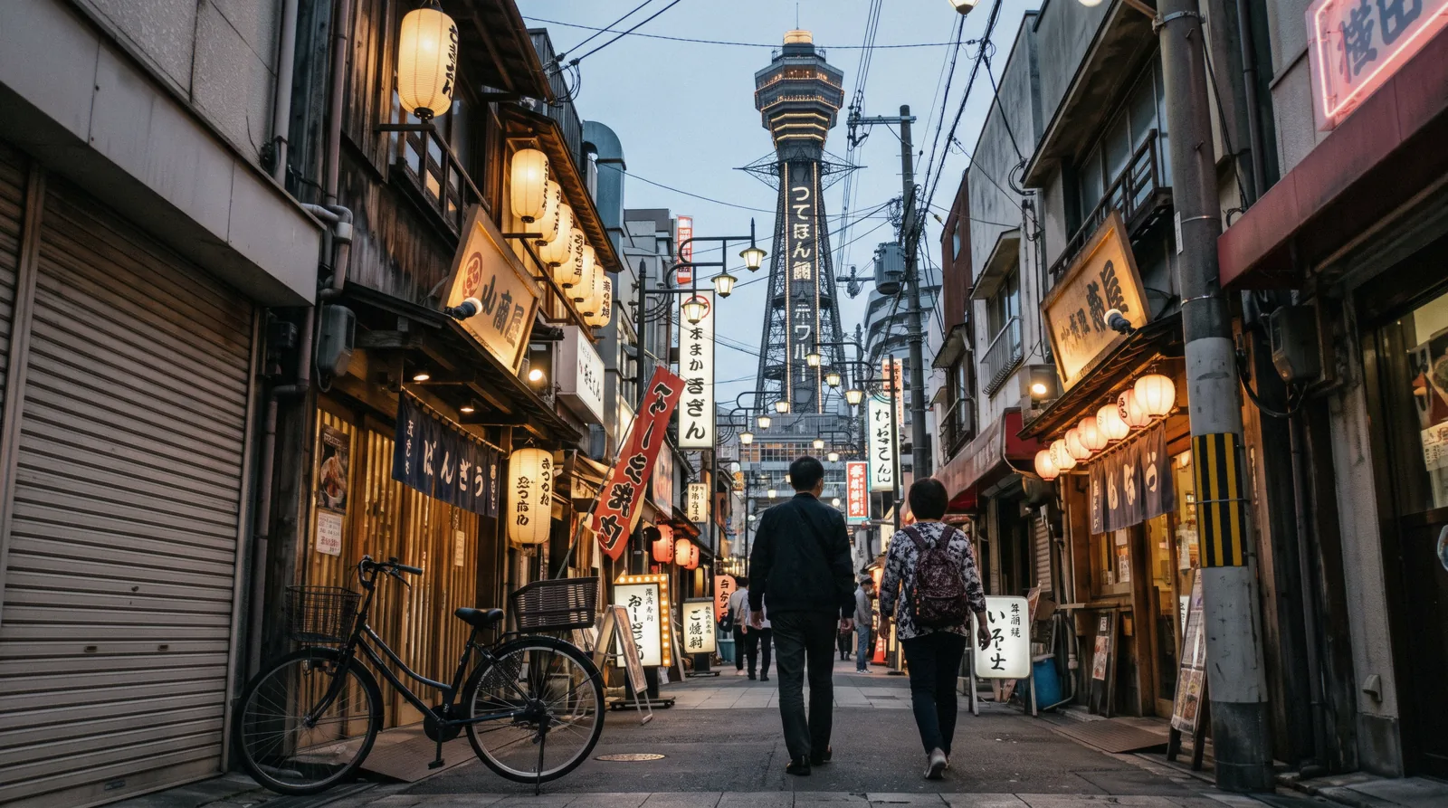 Neon signs and the pufferfish lantern over the kushikatsu streets of Shinsekai at dusk, Osaka Japan